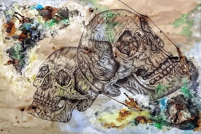 A drawing of two skulls on brown paper. There are patches of greens, blues, yellows and browns in the corners of the paper